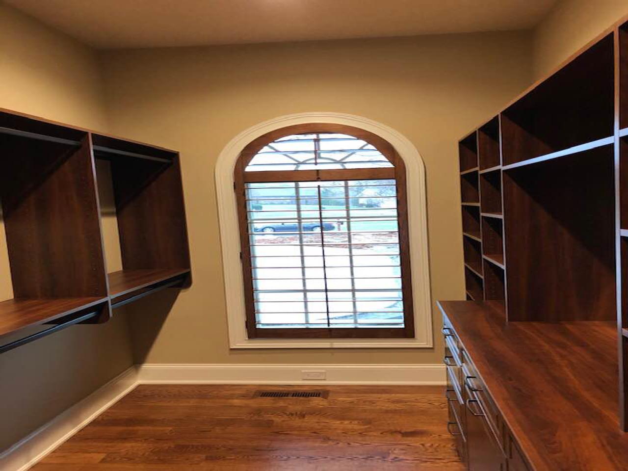 arched closet window with wood shutters