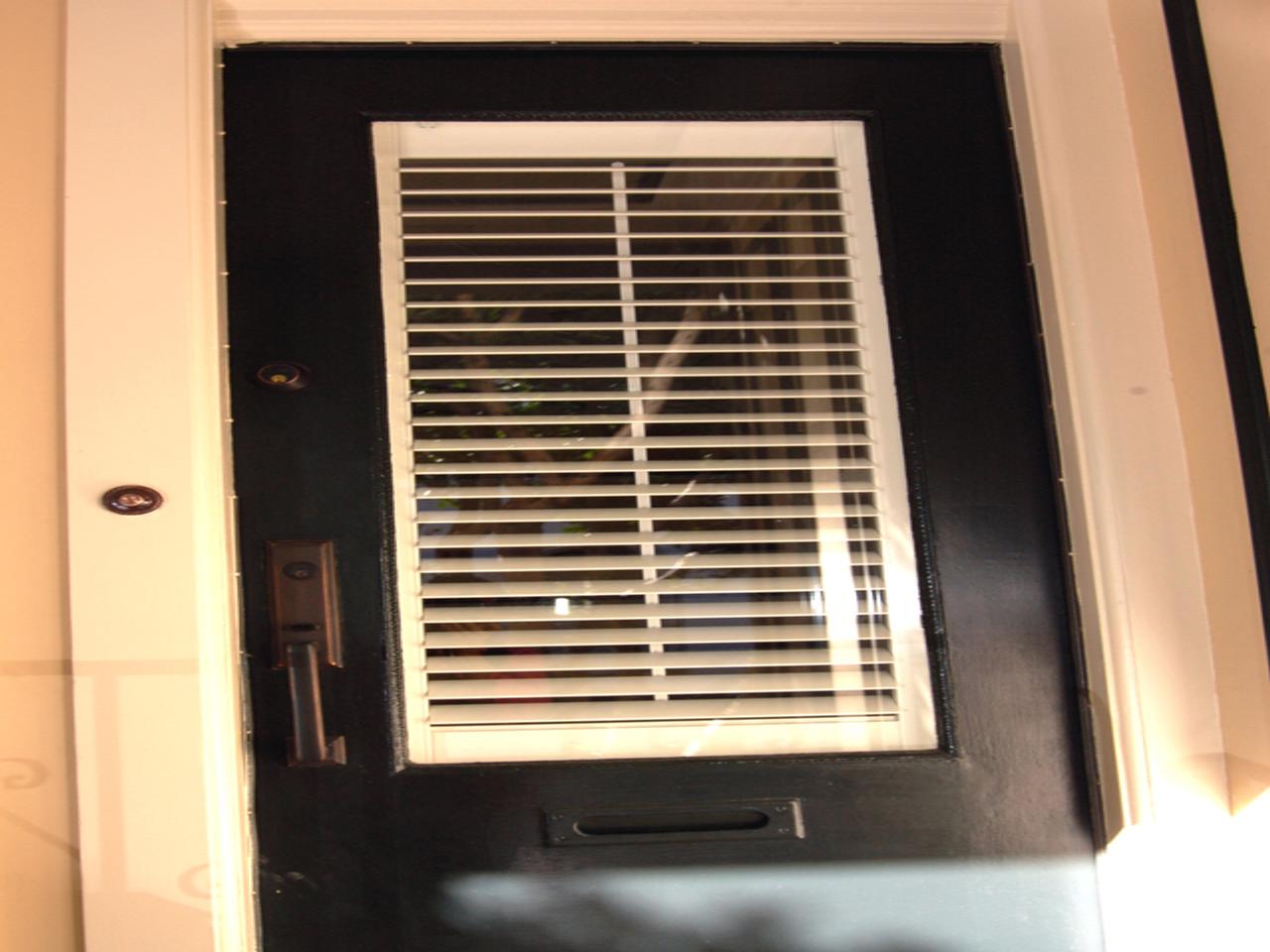 Shutters on a window on the top portion of a door