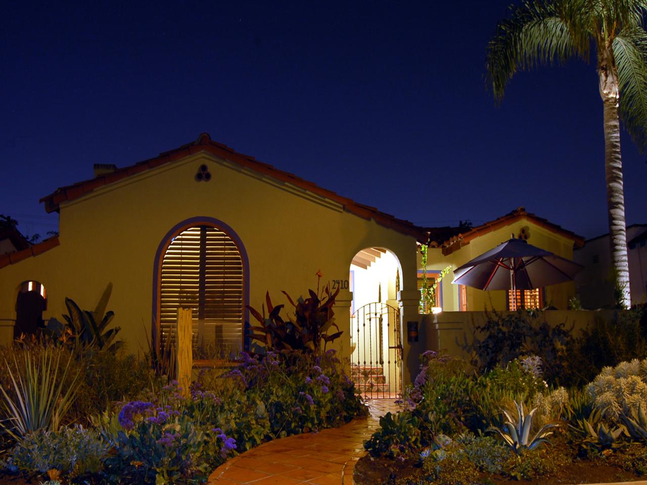 Outside view of mediterranean style home with stained arched shutters