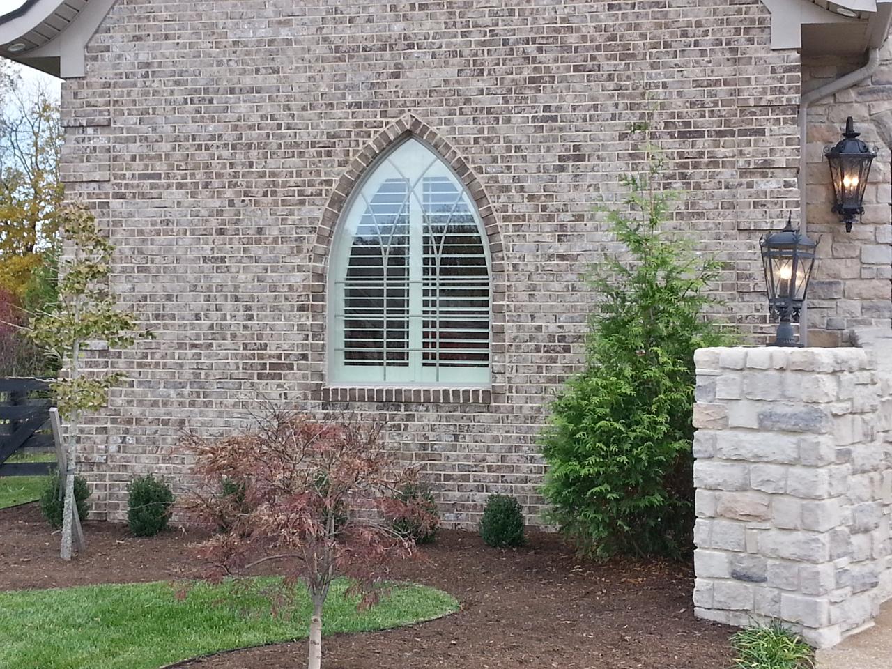 Uniquely shaped window with plantation shutters