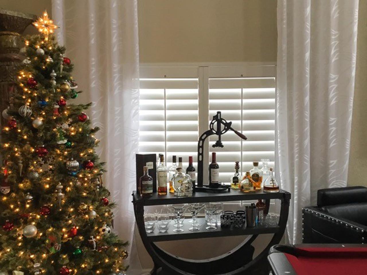 Christmas tree with bar and plantation shutters on the window