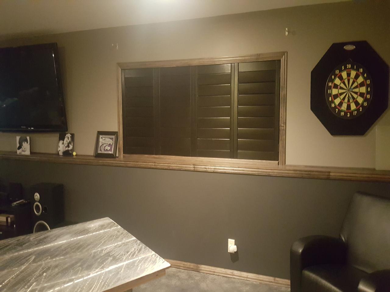 Stained shutters with louvers closed in a rec room