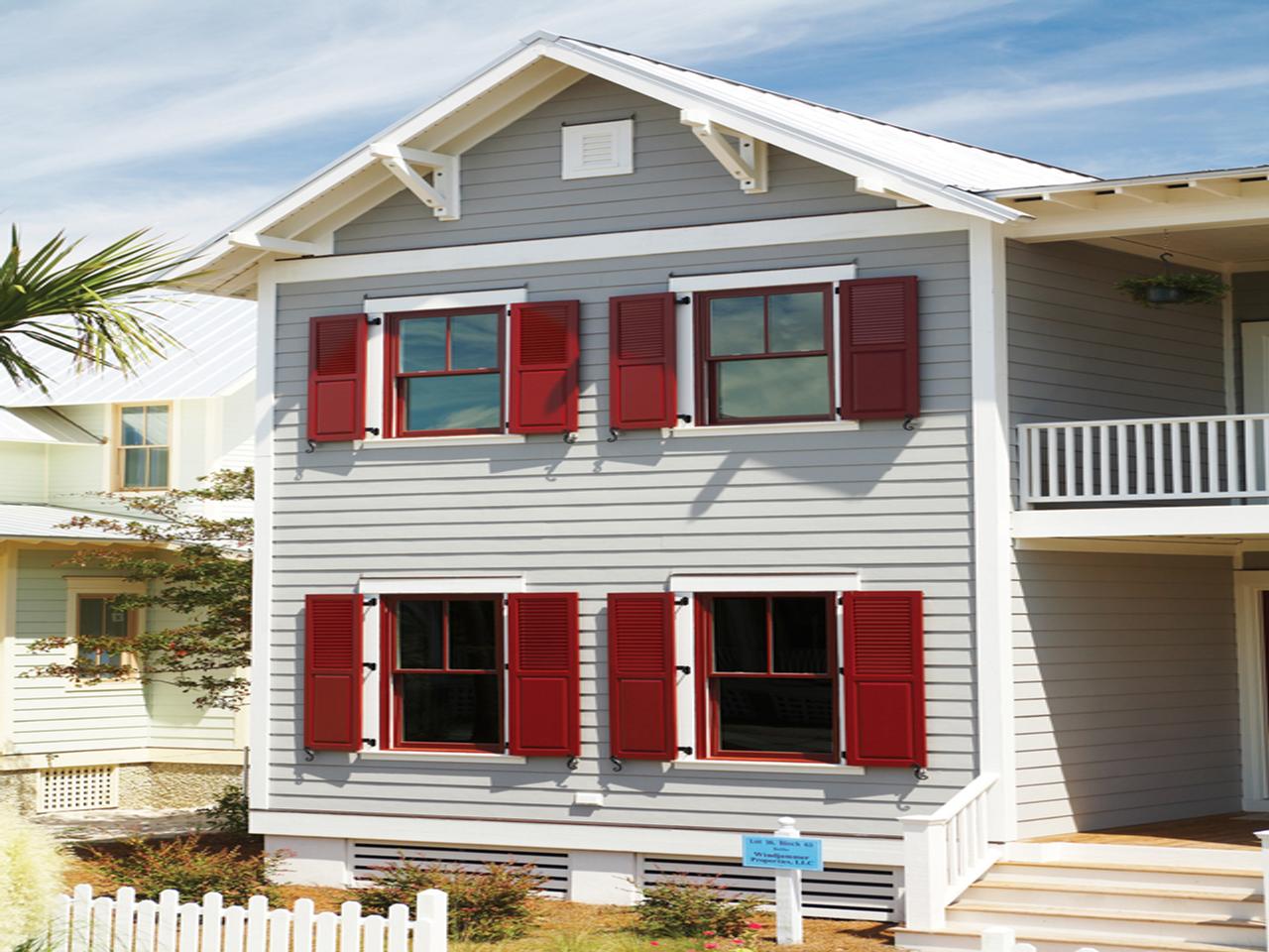 Solid and louvered shutters with hinges on a house