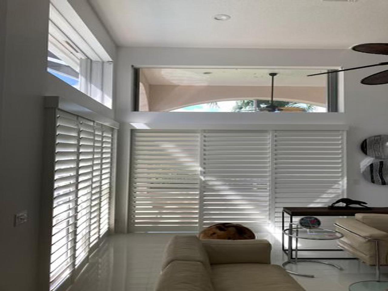 Sliding glass doors in living room with interior shutters