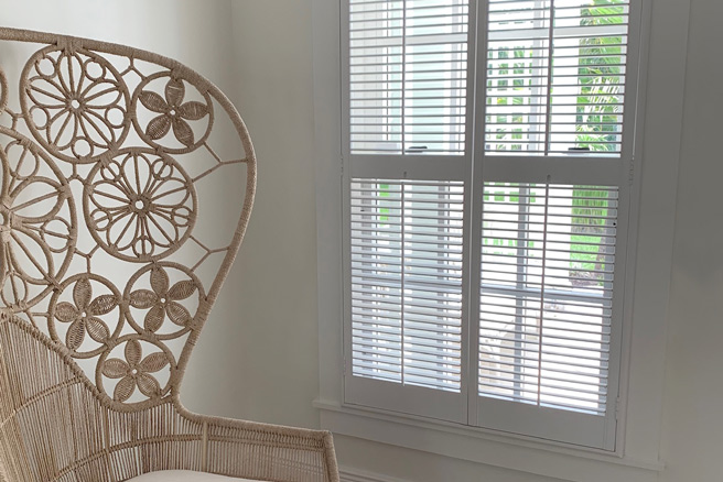 Traditional shutters by a chair