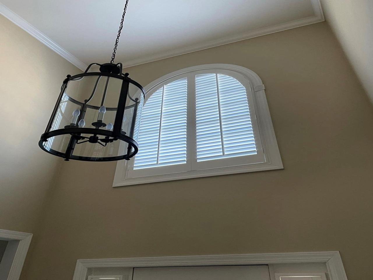 Arched window with shutters in foyer