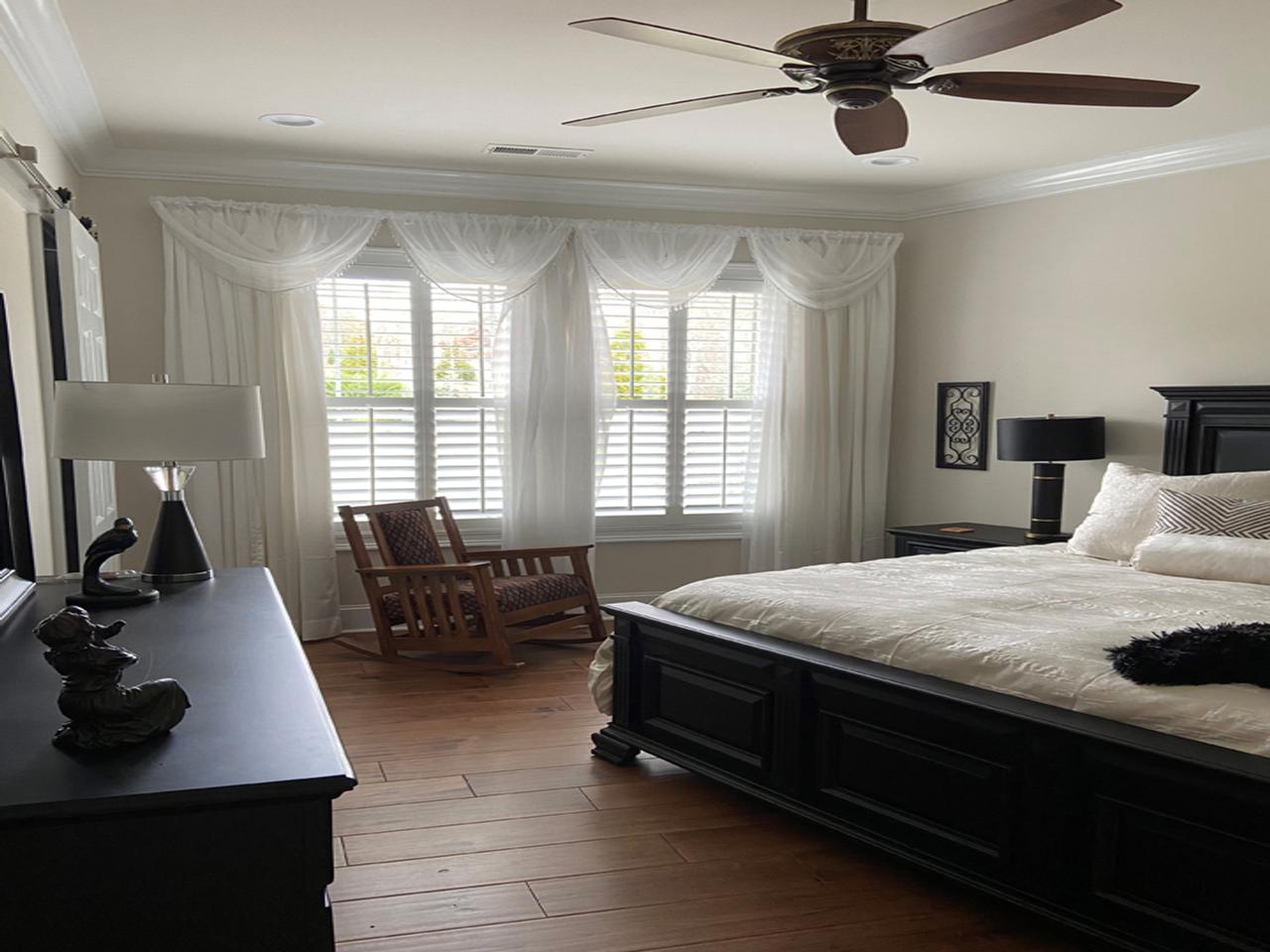 Bedroom with shutters and sheer drapes
