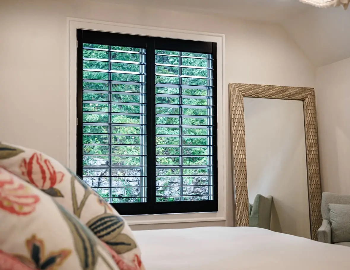 black plantation shutters on a bedroom window