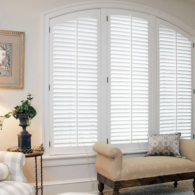 plantation shutters on arched window in sitting room