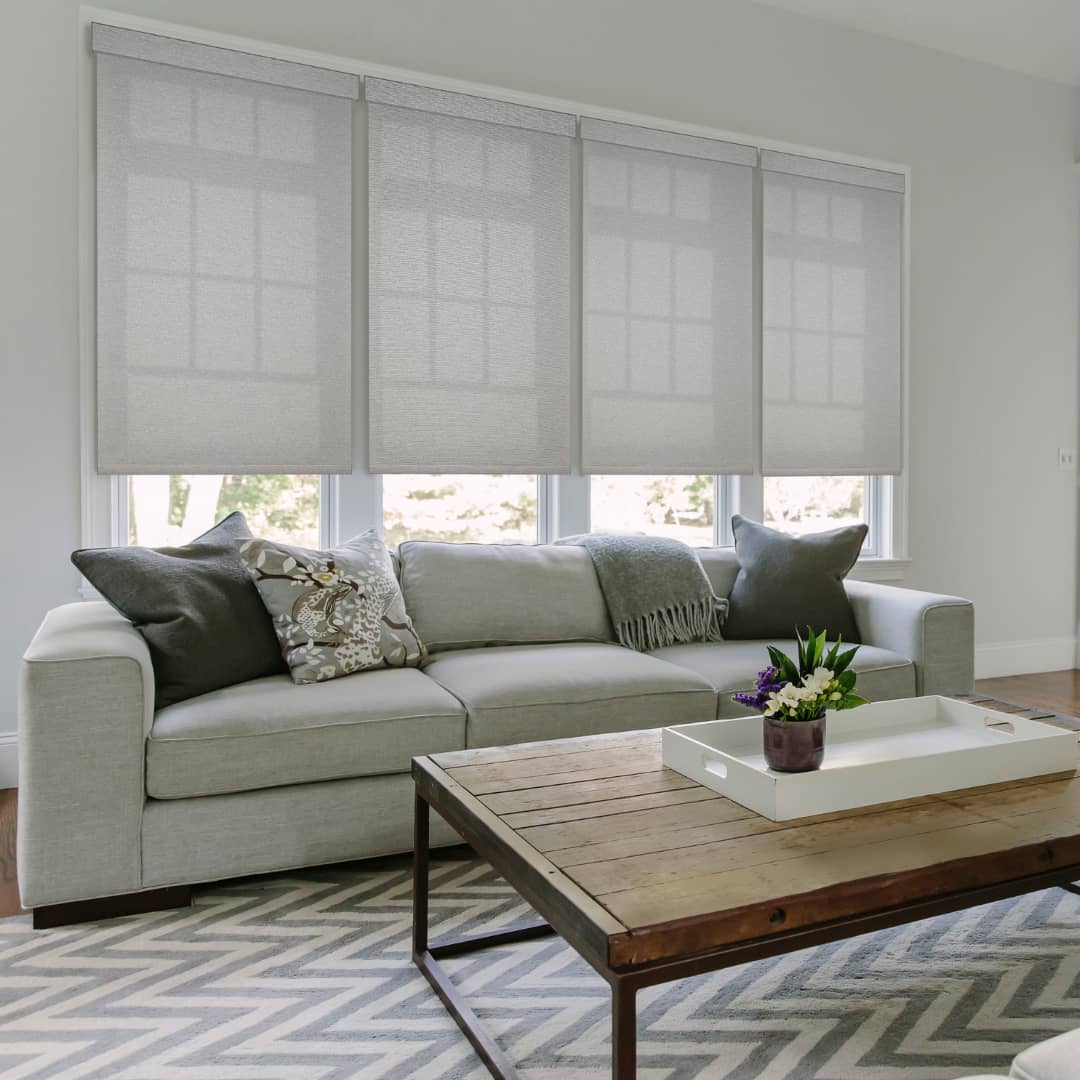 semi-sheer shades on large windows above a sofa