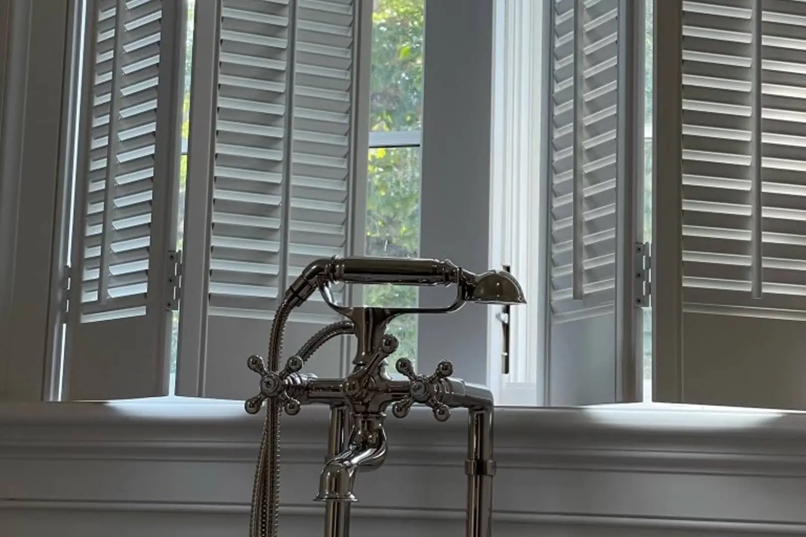 traditional wood shutters above a bath tub