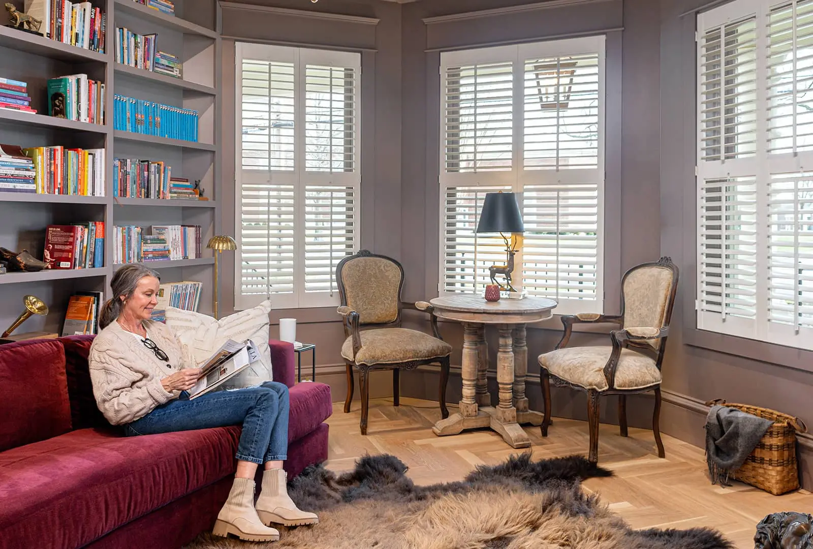 woman sitting in reading room with white shutters